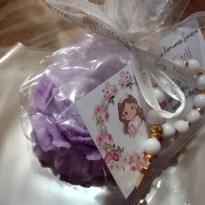Purple decorative hair clip with floral-patterned label and beaded details in plastic packaging