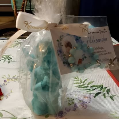 Handmade turquoise candle in cellophane wrapping with gift tag and card on decorated paper