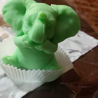 Bright green elephant figurine or soap sitting in a white pleated cupcake liner