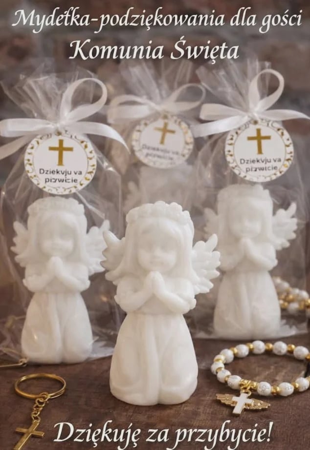 Three white ceramic angel figurines with hanging ornaments featuring crosses and Polish text, surrounded by prayer beads and a gold cross, promotional image for Holy Communion gifts