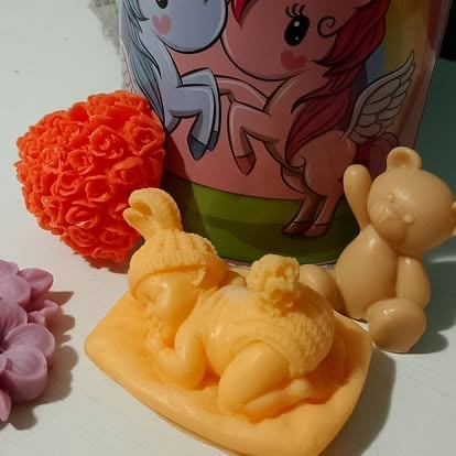 Yellow decorative rabbit figurine on orange platform with orange textured ball and small pink flowers